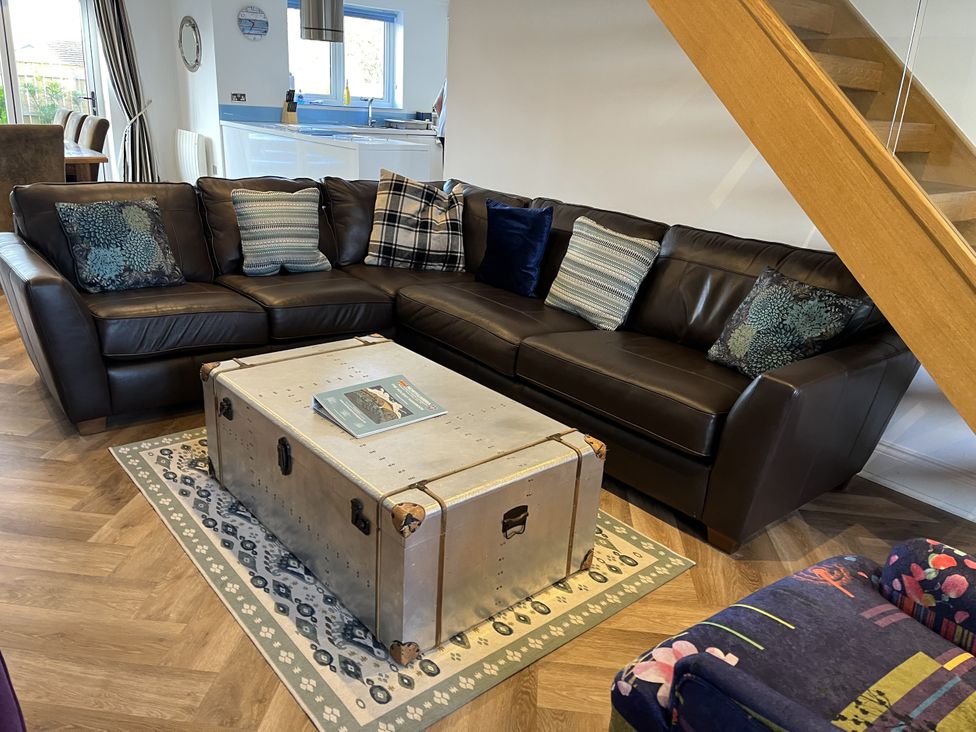 A living room with a sofa and a coffee table at Farne Cottage in Beadnell