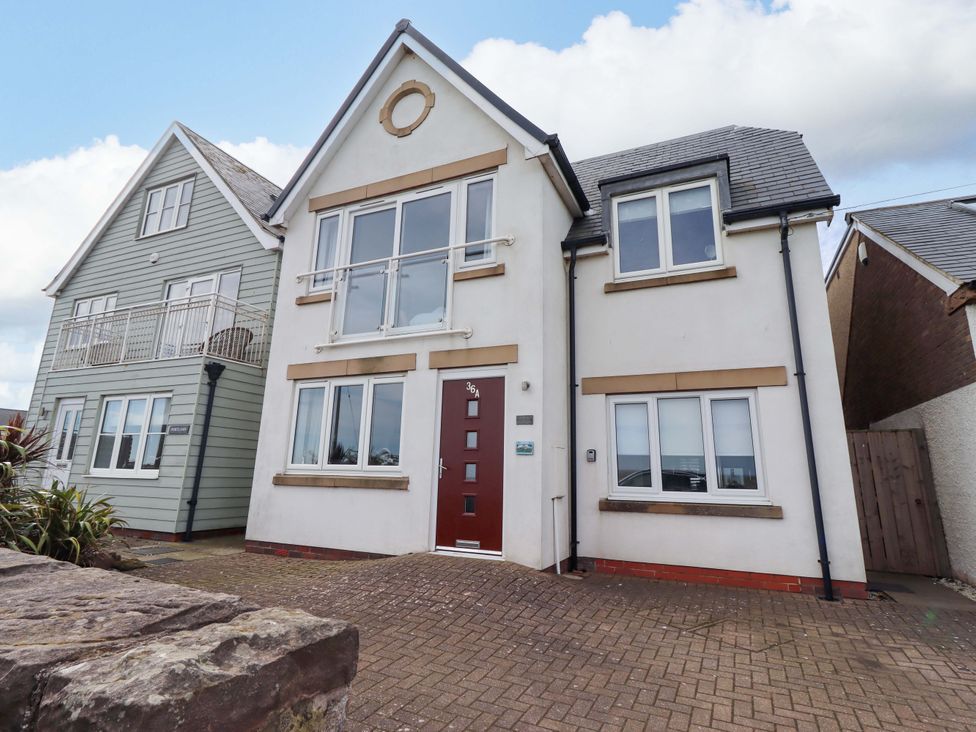 A house with multiple windows and a front door at Farne Cottage in Beadnell