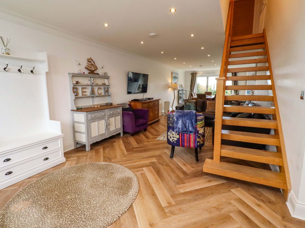 A living room with staircase and sofa at Farne Cottage Beadnell