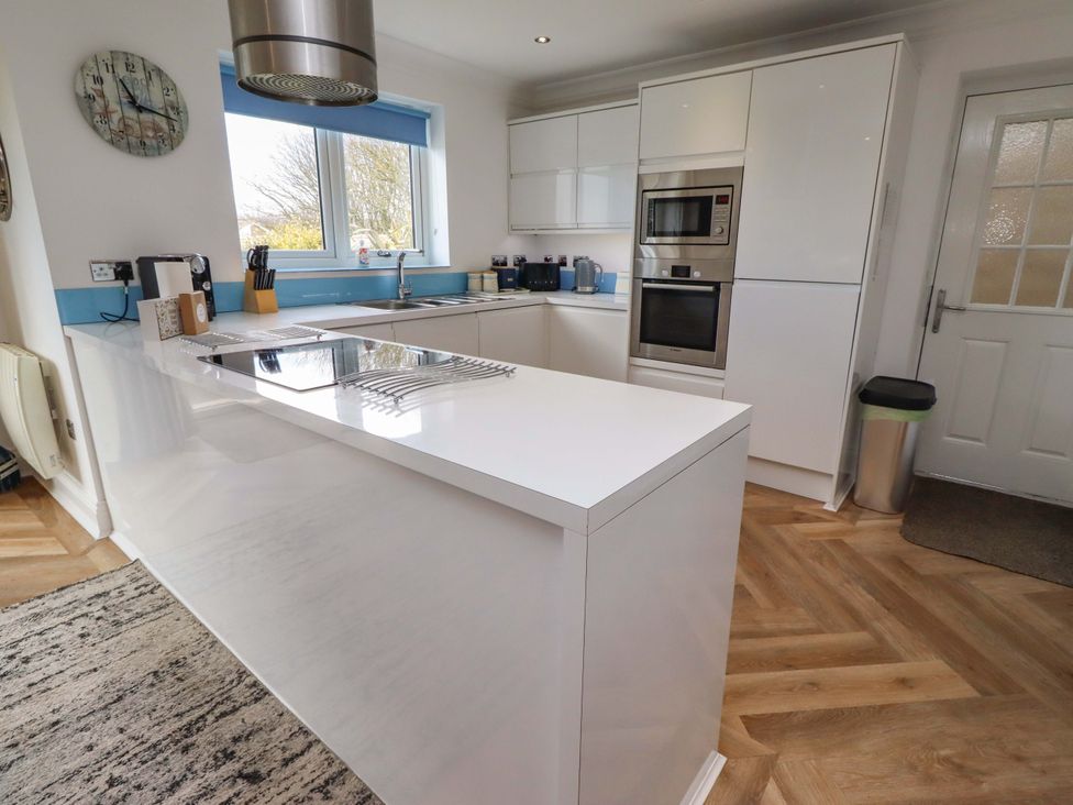 A kitchen with modern cabinetry and appliances at Farne Cottage Beadnell