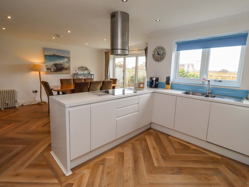 A kitchen with a countertop and dinner table at Farne Cottage Beadnell