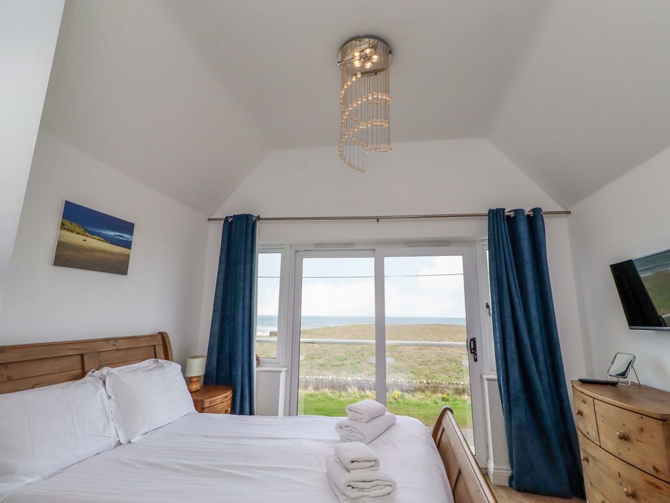 A bedroom with a bed and window at Farne Cottage Beadnell