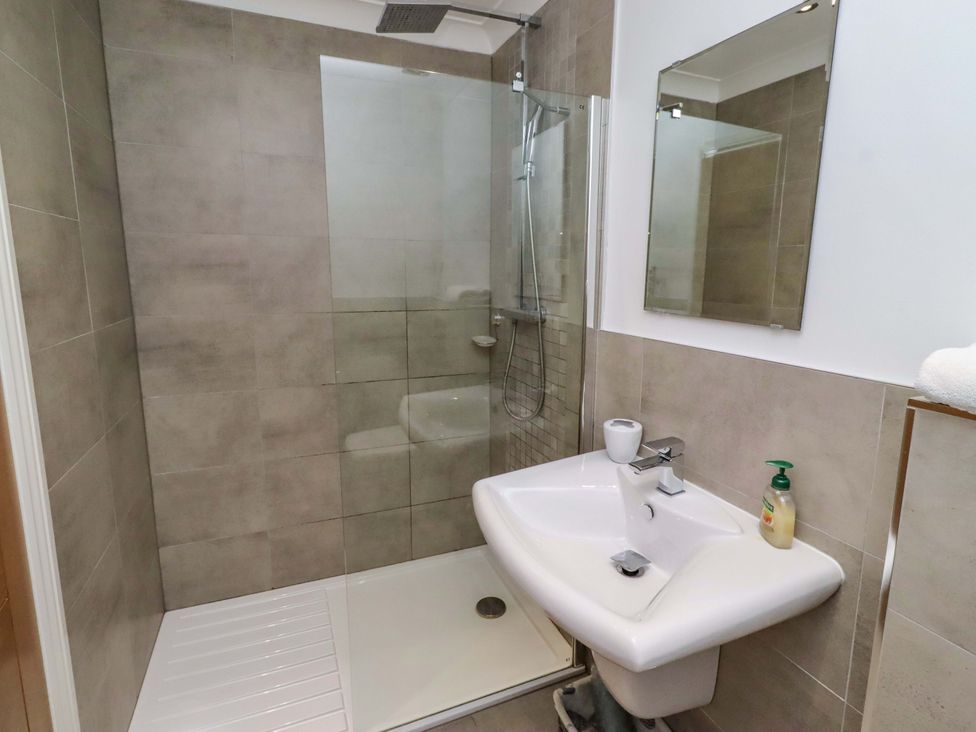 A bathroom with a shower and sink at Farne Cottage Beadnell