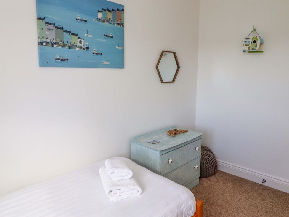 A bedroom with a bed and a dresser at Farne Cottage in Beadnell