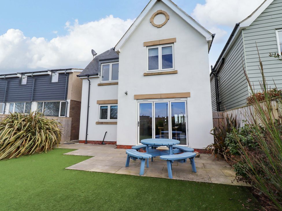 A house with a garden and outdoor seating area at Farne Cottage Beadnell