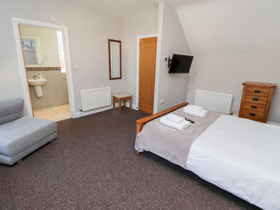 A bedroom with a bed and armchair at Russet in Lucker