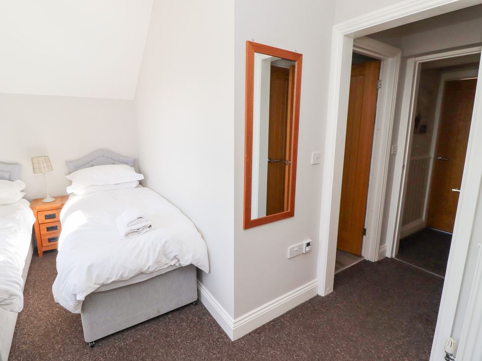 A bedroom with two beds and a mirror at Russet in Lucker