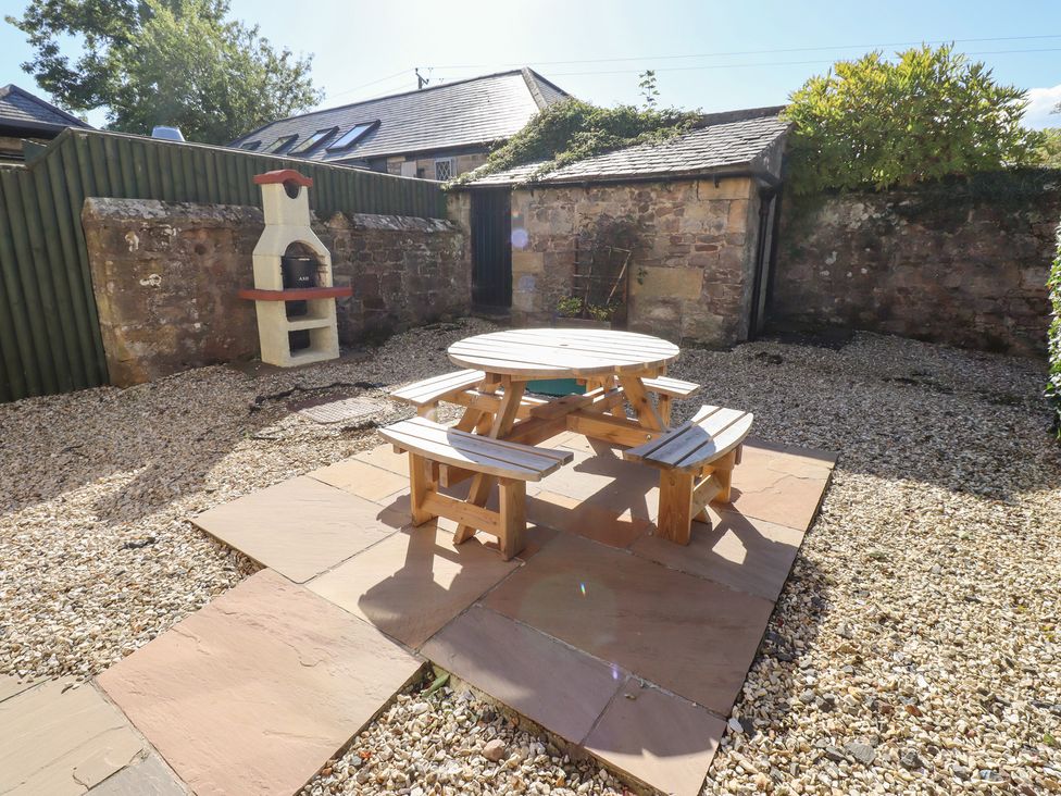 A garden with a table and benches at Russet in Lucker