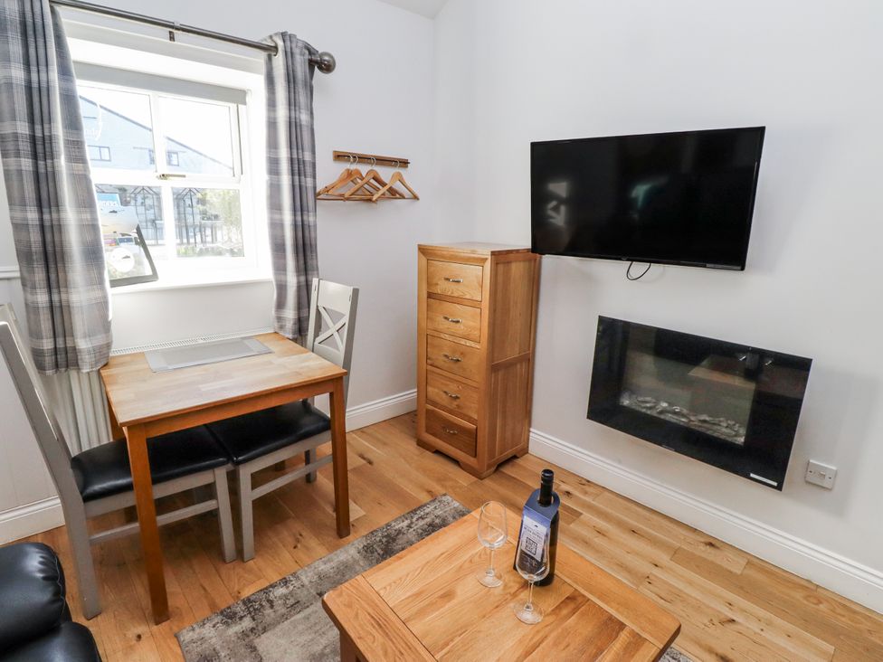 A dining area with a table and chairs at Avocet Cottage - Lucker Steadings Lucker
