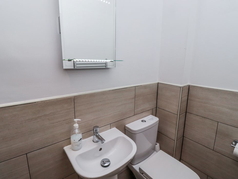 A bathroom with a sink and toilet at Avocet Cottage - Lucker Steadings, Lucker