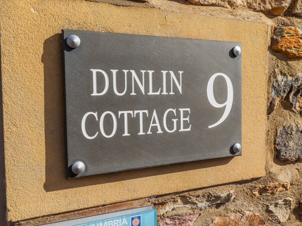 Nameplate displaying Dunlin Cottage 9 on a wall