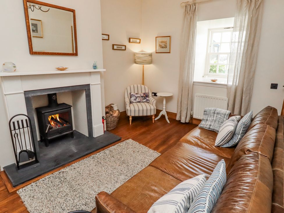 A living room with a fireplace and a sofa at No9 Budle Sands in Bamburgh