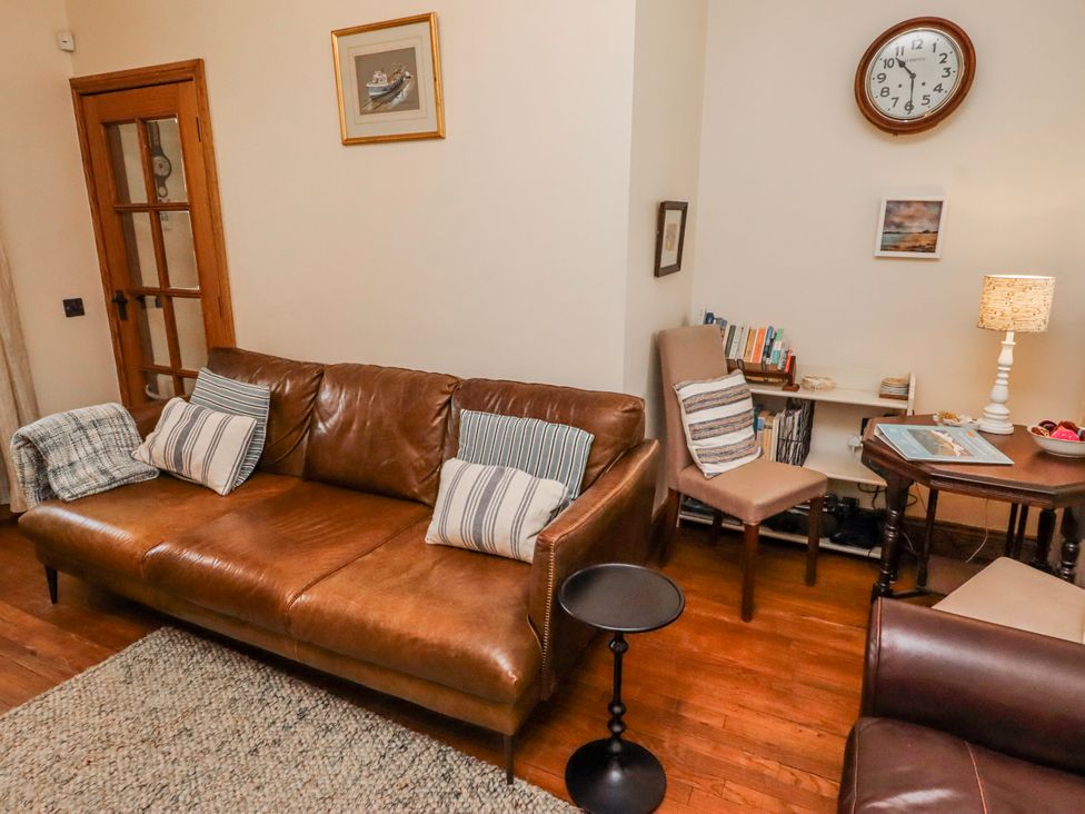 A living room with a sofa and armchair at No9 Budle Sands in Bamburgh
