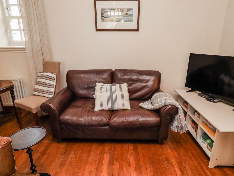A living room with a sofa and television at No9 Budle Sands in Bamburgh