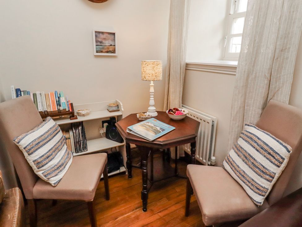 A sitting room with chairs and a table at No9 Budle Sands in Bamburgh