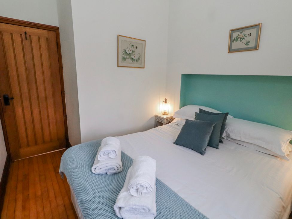 A bedroom with a double bed and artwork on the wall at No9 Budle Sands in Bamburgh