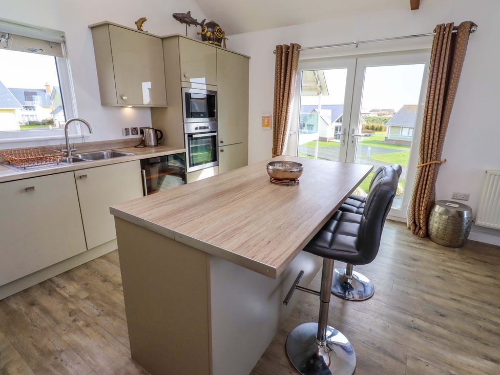 A kitchen with cabinets and a table at Spindrifter Beadnell