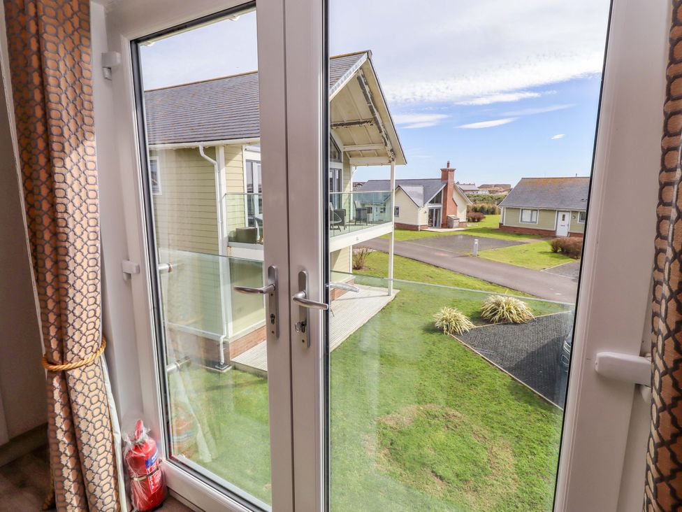 A view of houses and grass from a window at Spindrifter Beadnell