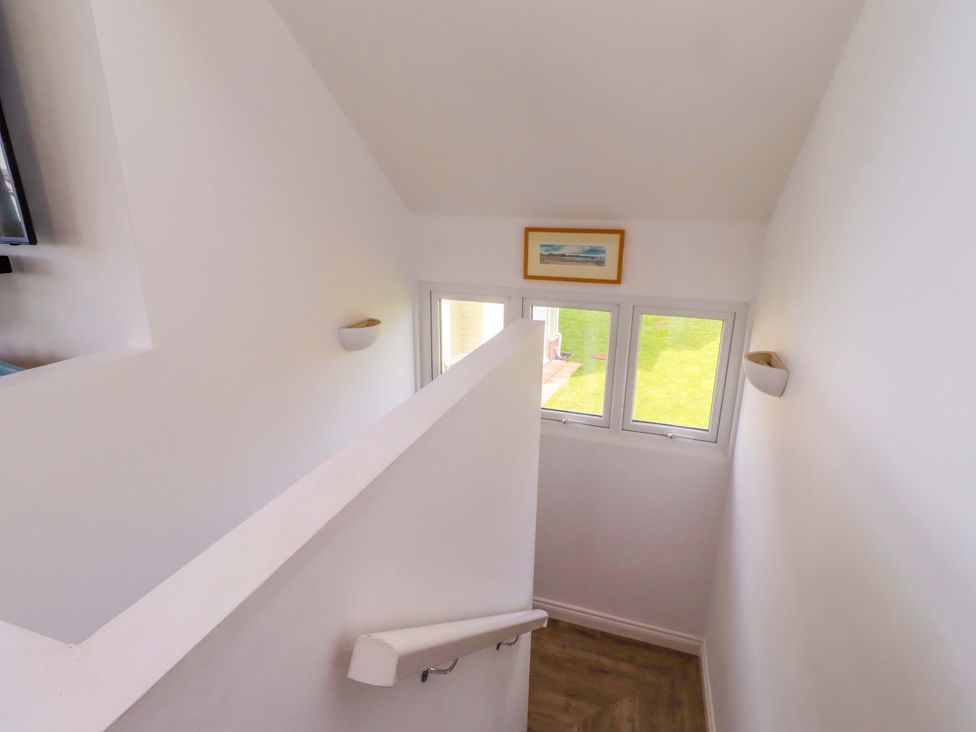 A stairway with handrail and windows at Spindrifter Beadnell