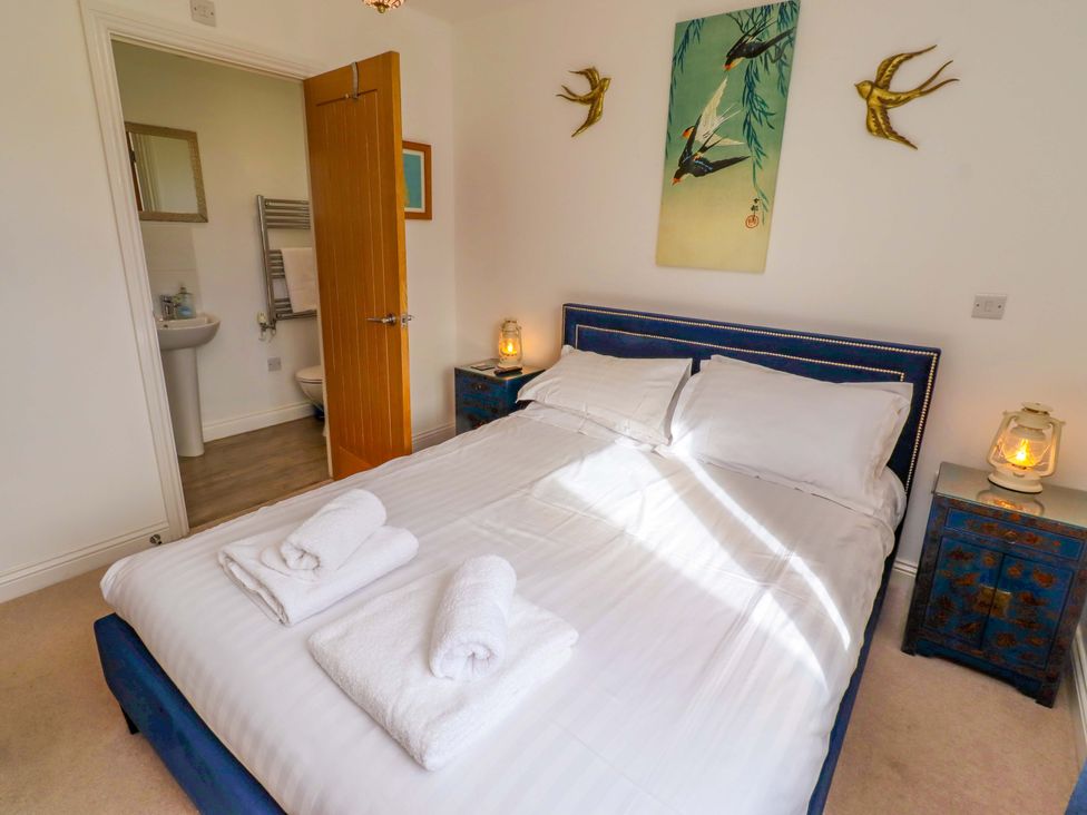 A bedroom with a bed and bedside tables at Spindrifter in Beadnell