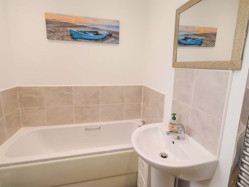 A bathroom with a bathtub and a sink at Spindrifter in Beadnell
