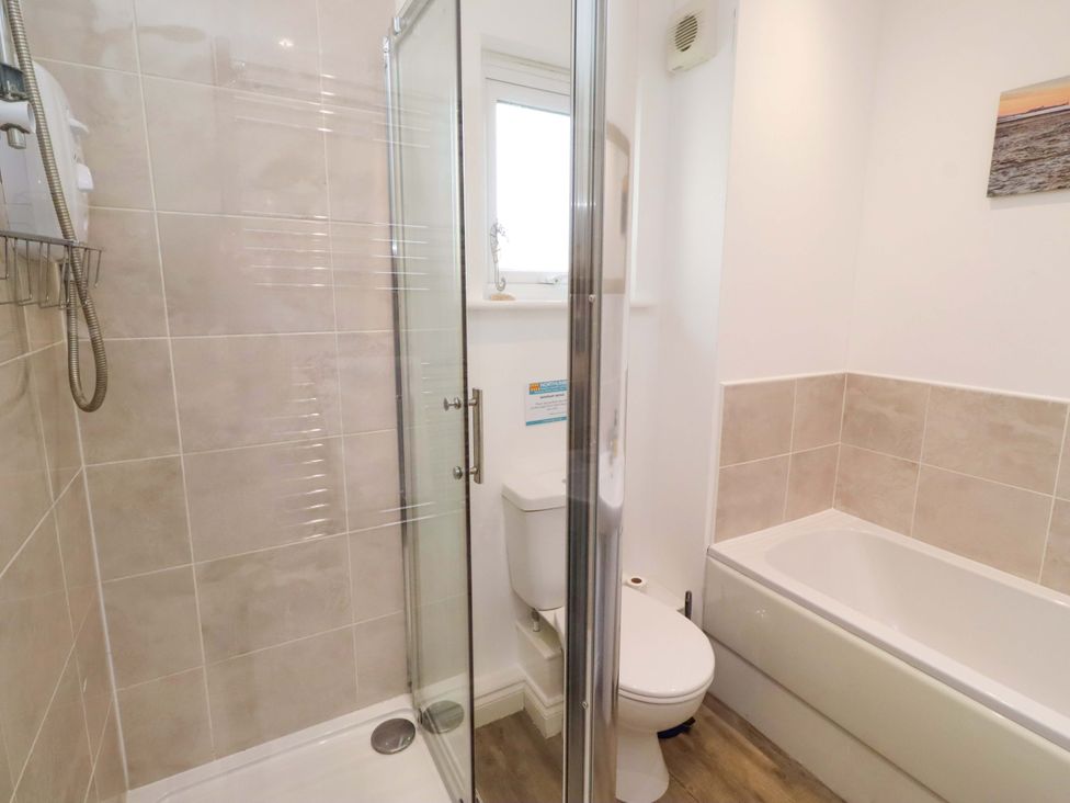 A bathroom with a shower and bathtub at Spindrifter Beadnell