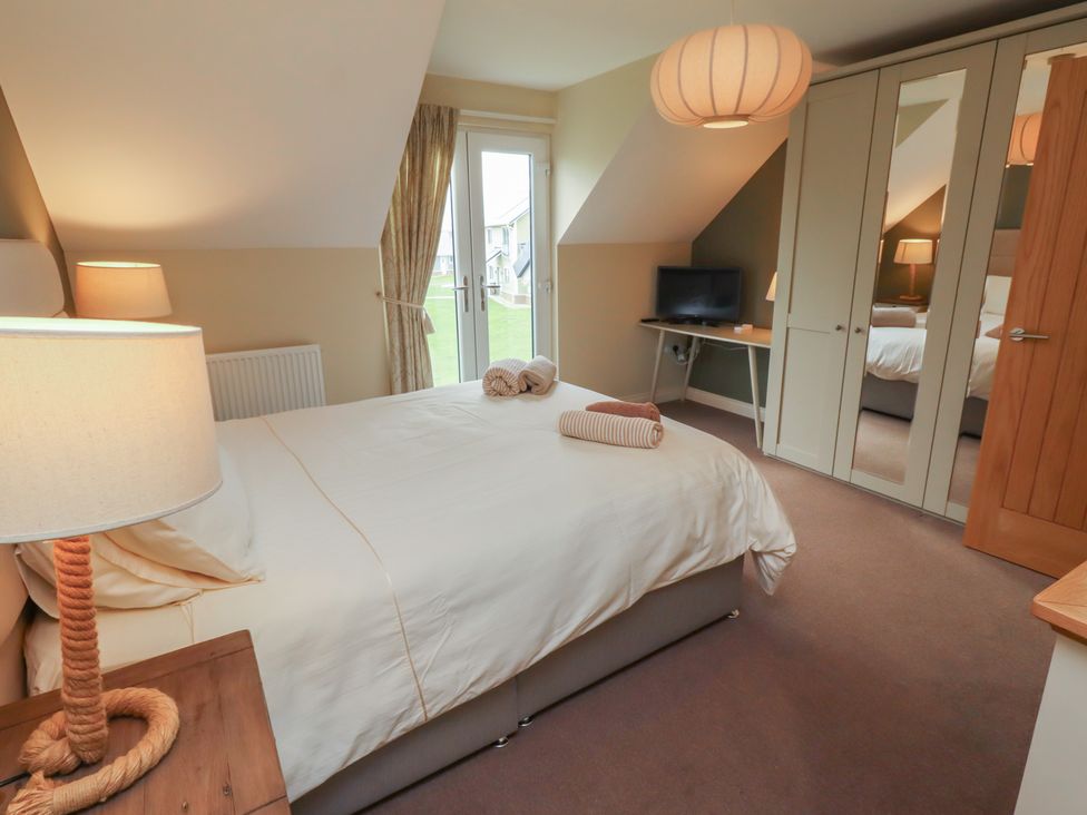 A bedroom with a bed and a television at The Beach Hut in Beadnell