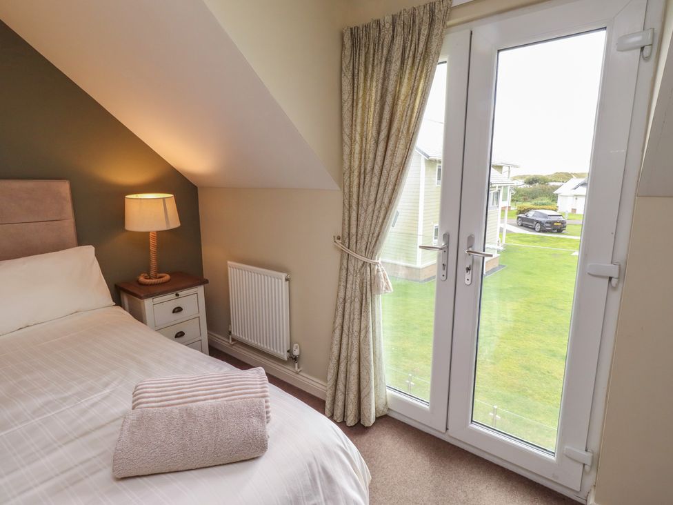 A bedroom with a bed and access to outdoor area at The Beach Hut in Beadnell