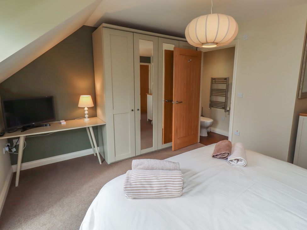 A bedroom with a bed and television at The Beach Hut in Beadnell