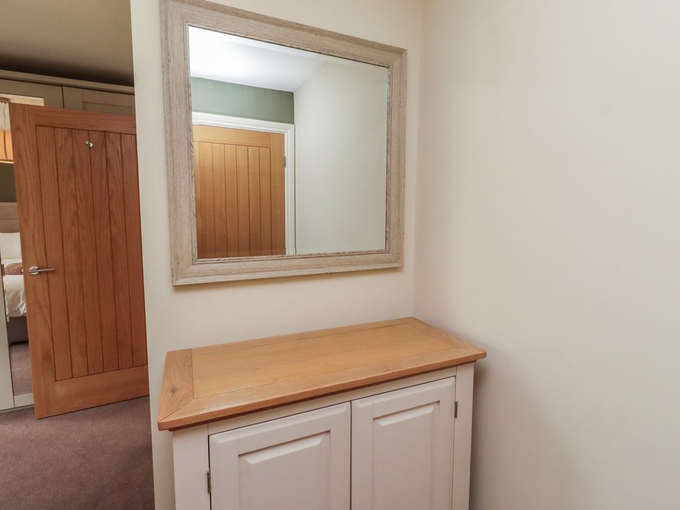 An entrance hall with a cabinet and mirror at The Beach Hut in Beadnell