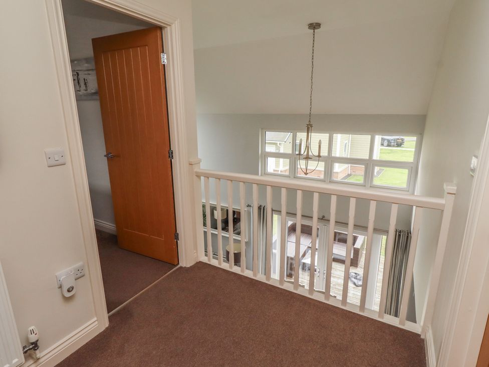 A landing with a door and a view of the outdoor area at The Beach Hut in Beadnell