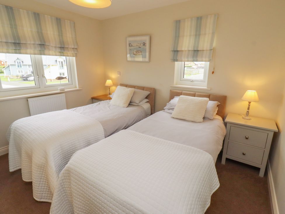 A bedroom with two single beds and bedside tables at The Beach Hut Beadnell