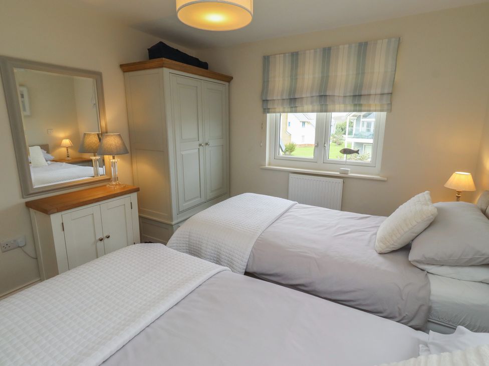 A bedroom with twin beds and a wardrobe at The Beach Hut in Beadnell