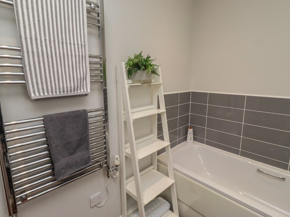 A bathroom featuring a towel rack and a bathtub at The Beach Hut in Beadnell