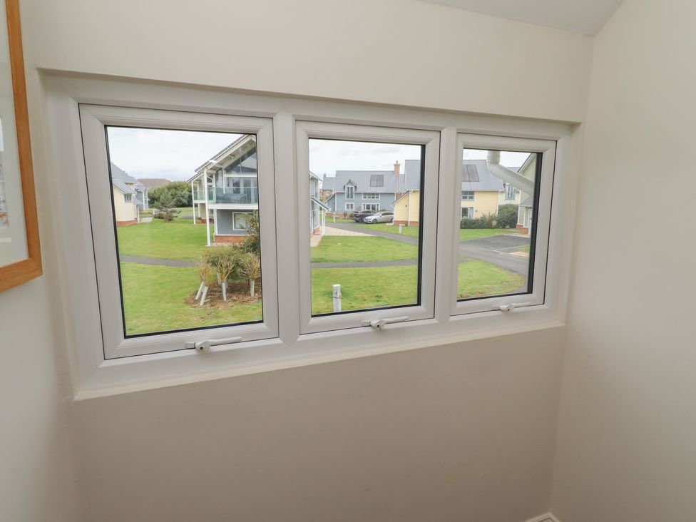 A window view showing buildings and grass at The Beach Hut in Beadnell
