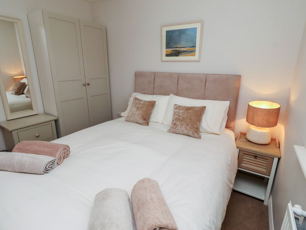 A bedroom with a bed and wardrobe at The Beach Hut in Beadnell