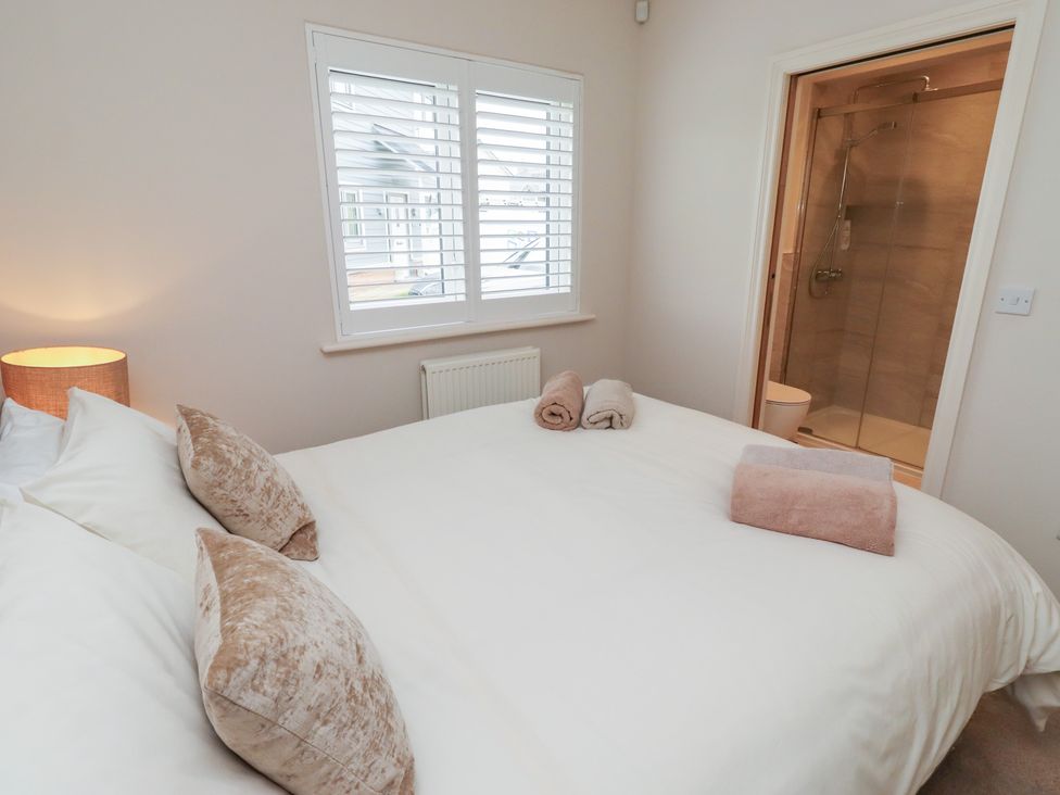 A bedroom with a double bed and an en-suite bathroom at The Beach Hut Beadnell