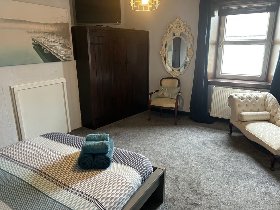 A bedroom with a bed and towels at Beach Retreat in Seahouses