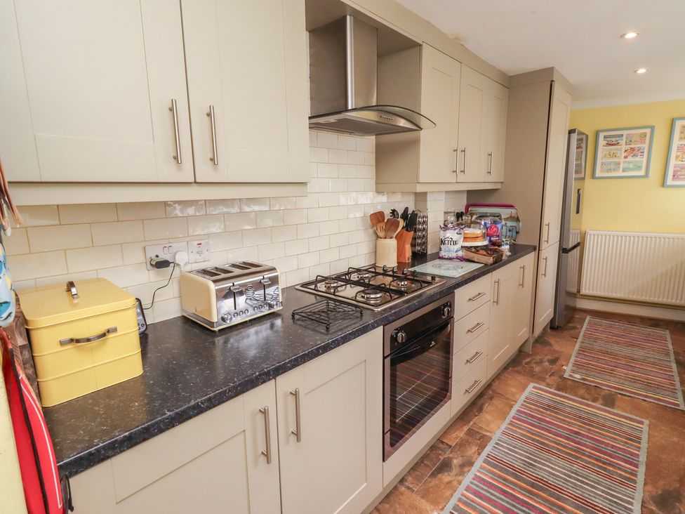 A kitchen with cabinets, stove, toaster, and fridge at Number Seventeen Amble