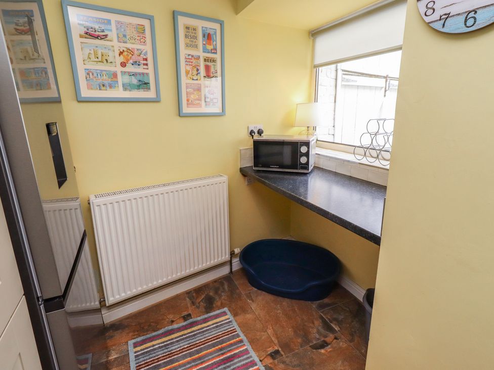 A kitchen with a microwave and pet bowl at Number Seventeen in Amble