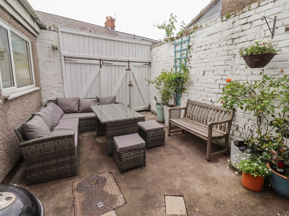 An outdoor patio area with seating and plants at Number Seventeen Amble