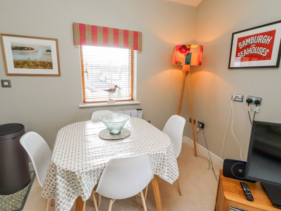 A dining room with a table and chairs at Cuddy's Holm in Seahouses