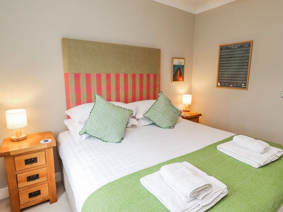 A bedroom with a bed and two bedside tables at Cuddy's Holm in Seahouses