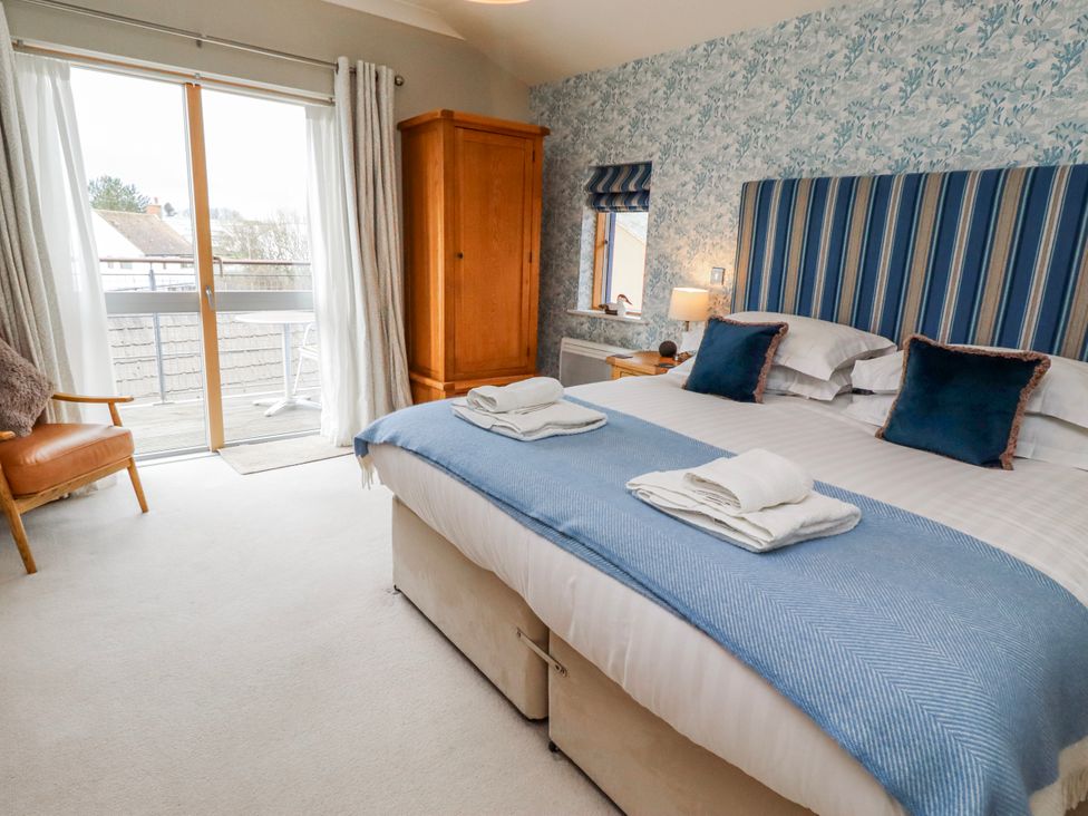 A bedroom with a bed and an armchair at Cuddy's Holm Seahouses