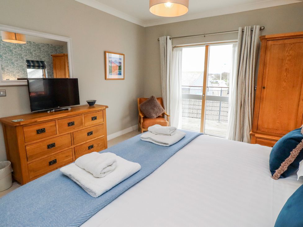 A bedroom with a bed and television at Cuddy's Holm in Seahouses