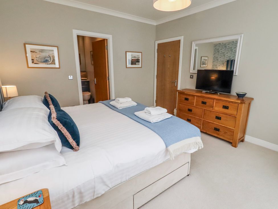 A bedroom with a bed and television at Cuddy's Holm in Seahouses