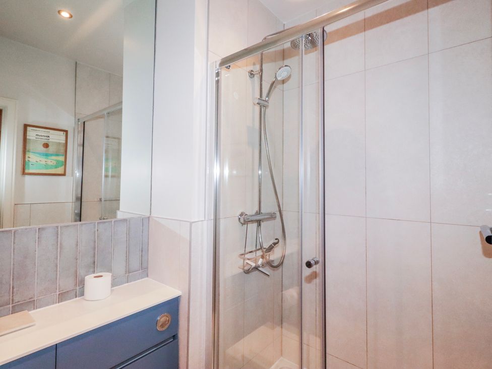 A bathroom with a shower and sink at Cuddy's Holm in Seahouses