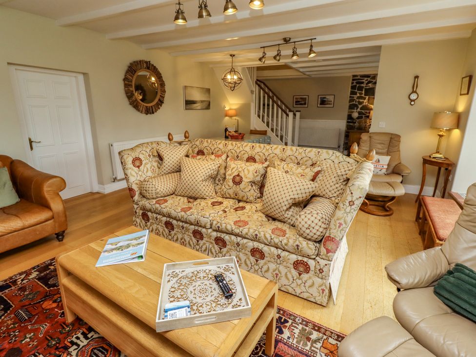 A living room with a sofa and coffee table at Coble Cottage in Craster