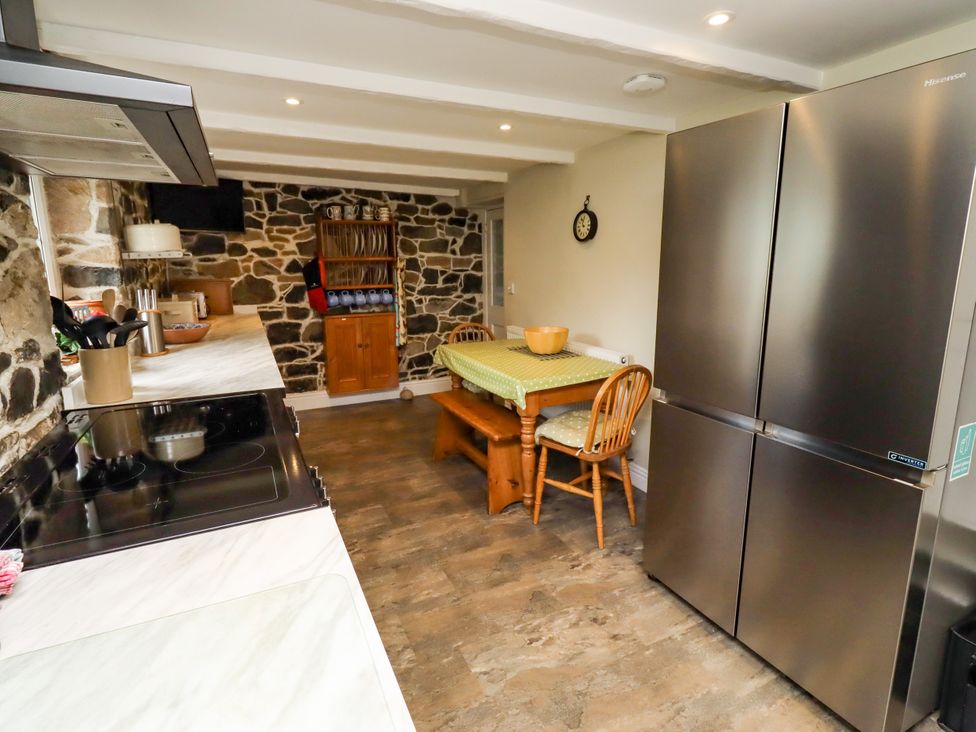 A kitchen with a table and chairs at Coble Cottage in Craster