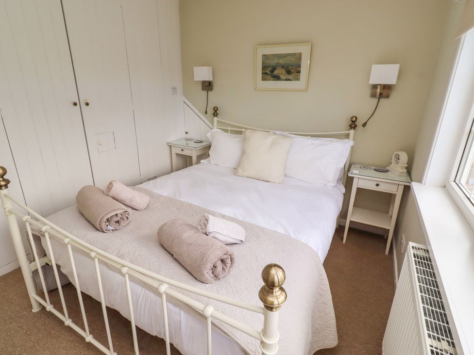 A bedroom with a bed and bedside table at Coble Cottage in Craster